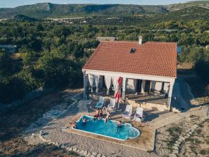 an aerial view of a house with a swimming pool at Holiday home with pool Kristal in Šibenik