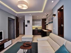 uma sala de estar com um sofá branco e uma cozinha em Luna apartment em Budapeste