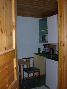 a kitchen with a counter and a table and a chair at Rinne in Rymättylä