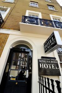 une porte menant à un hôtel de croix rois avec un panneau au-dessus de celui-ci dans l'établissement Kings Cross Hotel London, à Londres