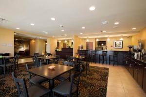 a restaurant with tables and chairs and a bar at Cobblestone Inn & Suites - Eads in Eads