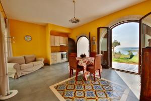 un soggiorno con pareti gialle, tavolo e divano di Villa i Giardini di Limoni by KlabHouse a Sciacca