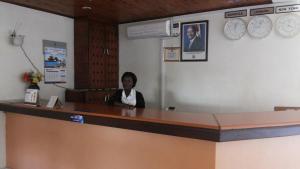 a woman sitting at a counter in a waiting room at Zawadi Hotel in Adjumani
