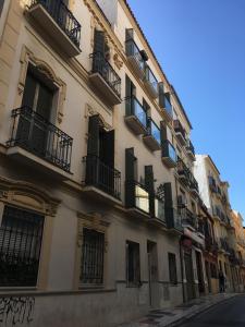 a tall building with balconies on a city street at Modern studio flat close to Plaza Merced in Málaga