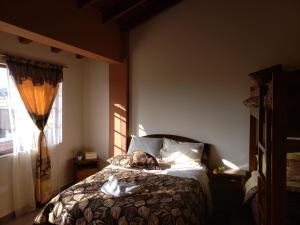 a dog sleeping on a bed in a bedroom at Hospedaje San Fernando in Cayambe