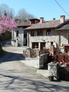 a large stone house with a road in front of it at Corte del Rondiellu 2 in Onís