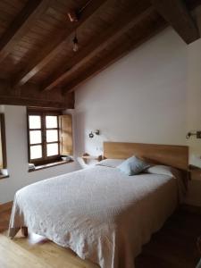 a bedroom with a large bed with a wooden headboard at Corte del Rondiellu 2 in Onís