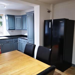 RocesterにあるNorthfield Houseのキッチン(木製テーブル、黒い冷蔵庫付)
