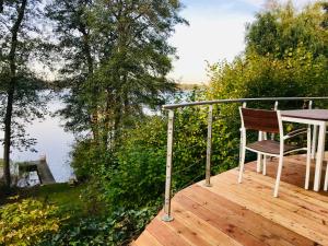 a chair sitting on a deck with a view of the water at Haus am Pinnower See in Pinnow