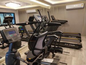 a gym with several treadmills and elliptical machines at Hotel De Sripoom in Chiang Mai