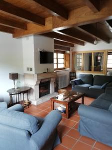 a living room with blue couches and a fireplace at Corte del Rondiellu 2 in Onís