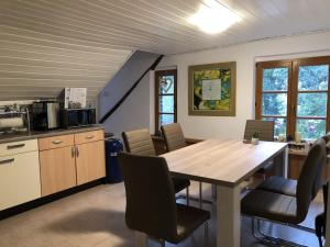 een keuken en eetkamer met een houten tafel en stoelen bij Ferienwohnung auf denkmalgeschütztem Sturmhof in Grefrath