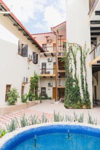 ザンジバルシティにあるAntonio Garden Hotelの建物の前にスイミングプールがある中庭
