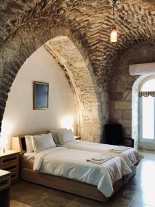 een slaapkamer met een groot bed in een stenen muur bij Christian Quarter Studio I in Jeruzalem