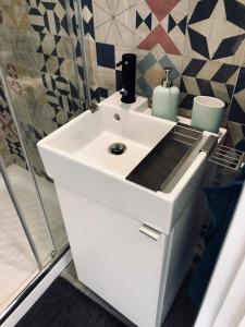 a bathroom with a white sink and a shower at Blue Flamingo Apartment in Torremolinos