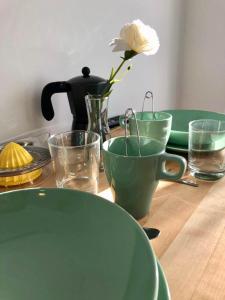 a table with green plates and a flower in a vase at Blue Flamingo Apartment in Torremolinos