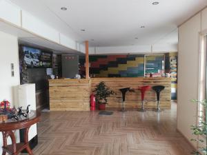Hostal Baquedano في بويرتو ناتالز: مطعم مع كونتر مع مقاعد على أرضية خشبية