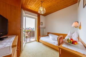 a hotel room with a bed and a window with a bowl of fruit at Chalet Anna in Marlengo +43 photos