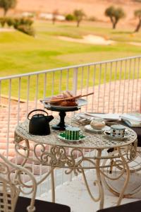 a table with a plate of food on a balcony at L'Andana Tenuta La Badiola in Castiglione della Pescaia