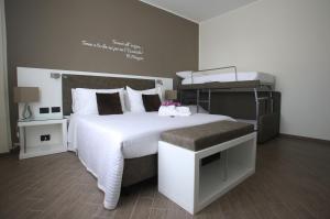 - une chambre avec un grand lit et un couvre-lit blanc dans l'établissement L`essenza B&B, à Reggio de Calabre