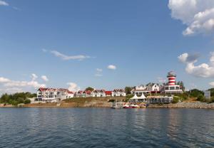 um grupo de casas e um farol sobre a água em Der LeuchtTurm-Gastro GmbH em Geierswalde