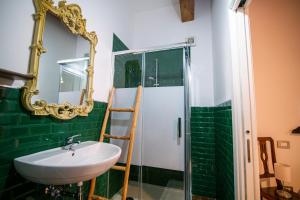 a bathroom with a sink and a shower with a mirror at Redmood Guesthouse in Barletta