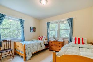 Seal Cove的住宿－Compass Rose，一间卧室设有两张床、一把椅子和窗户。