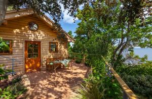 uma casa de madeira com uma mesa e uma cadeira num alpendre em Porthole Log Cabin em Minehead