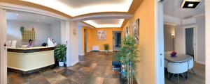 a lobby with a counter and potted plants at Hotel Alessandra in Garda