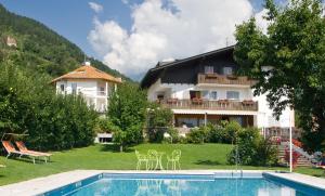 a resort with a swimming pool and a house at Chalet Anna in Marlengo