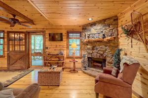 uma sala de estar em chalé de madeira com uma lareira de pedra em Cozy Bear em Sautee Nacoochee