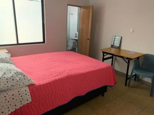 a bedroom with a bed and a desk and a table at Casa Tuvia in Medellín