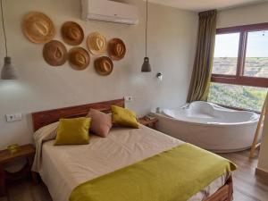 Casas del CerroCasas Rurales Maribel - Complejo Moradas del Cerro 1 - Suites con Jacuzzi en Alcalá del Júcar的带床和浴缸的卧室