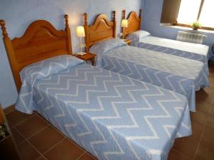 two beds in a hotel room with blue sheets at MAS CAN SALVI in Parlavà