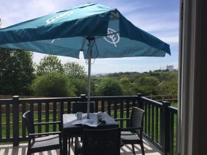 a table with a blue umbrella on a deck at Brighton Experience Freedom Glamping in Brighton & Hove