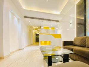 uma sala de estar com um sofá e uma mesa em Hotel City Empire em Nova Deli