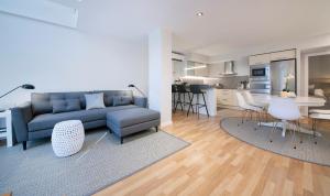 a living room with a blue couch and a kitchen at Poble Nou II You Stylish Apartments in Barcelona