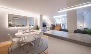 a kitchen and dining room with a white table and chairs at Poble Nou II You Stylish Apartments in Barcelona
