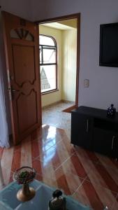 a living room with a door and a table and a tv at Ven a disfrutar de una maravillosa estadía in Sabaneta