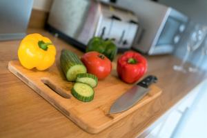 a cutting board with vegetables and a knife on a counter at Church View Irene Court Cockermouth in Cockermouth +70 photos