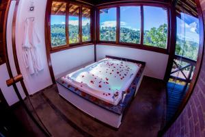 a room with a bed in a room with windows at Pousada Vida Verde in Gonçalves