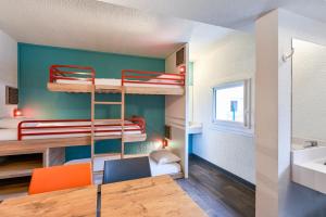 a small room with bunk beds and a table and chairs at hotelF1 Chaumont in Chaumont
