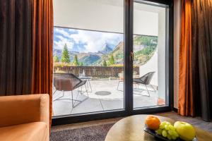 a room with a large glass door with a view of a patio at The Christiania Mountain Spa Resort in Zermatt