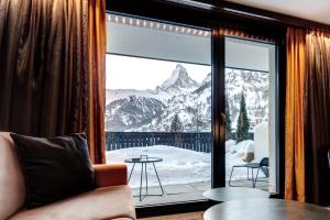 um quarto com uma janela com vista para uma montanha em The Christiania Mountain Spa Resort em Zermatt