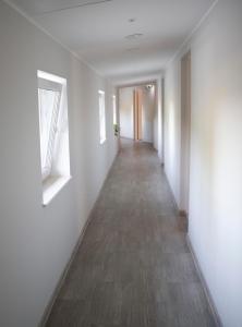 an empty hallway with white walls and wood floors at OXCafe Hostel in Kose-Uuemõisa