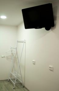 OXCafe Hostel في Kose-Uuemõisa: تلفزيون بشاشة مسطحة معلق على جدار أبيض