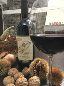 un bicchiere di vino accanto a una bottiglia di vino e noci di KATOQI - Casa turistica nel Parco del Pollino - Basilicata a San Paolo Albanese