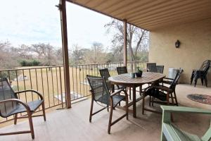 a patio with a wooden table and chairs on a balcony at Riverside Retreat in New Braunfels