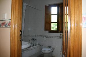 baño con lavabo y aseo y ventana en Casa Pousadoira, en Miño