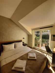 um quarto com uma cama grande com duas toalhas em Urban Lodge Belgrade em Belgrado